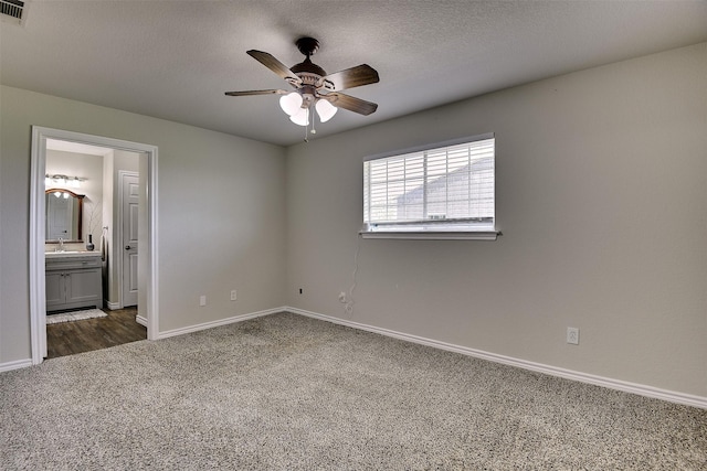 351 Marion Rd, Venus, TX 76084 - unfurnished bedroom with dark carpet, connected bathroom, a ceiling fan, and a textured ceiling