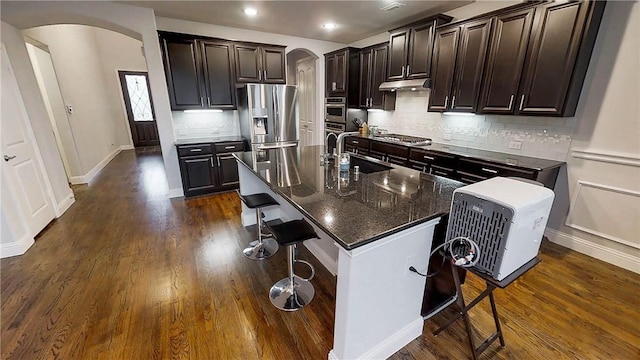 1320 Ponca St, Carrollton, TX 75010 - kitchen with arched walkways, stainless steel appliances, a breakfast bar, and recessed lighting