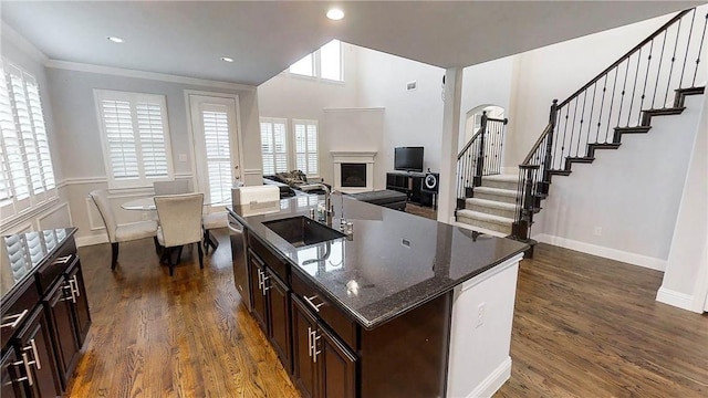 1320 Ponca St, Carrollton, TX 75010 - kitchen with a fireplace, dark wood-type flooring, dark stone counters, an island with sink, and recessed lighting