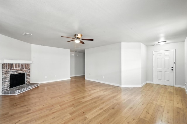 1908 Ramada Trl, Fort Worth, TX 76247 - unfurnished living room with ceiling fan, light wood-style flooring, and a brick fireplace
