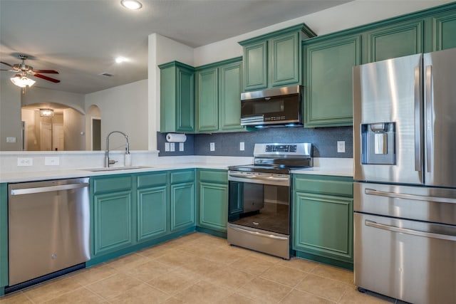 9032 Eagle Dr, Providence Village, TX 76227 - kitchen featuring stainless steel appliances, light countertops, arched walkways, green cabinets, and recessed lighting