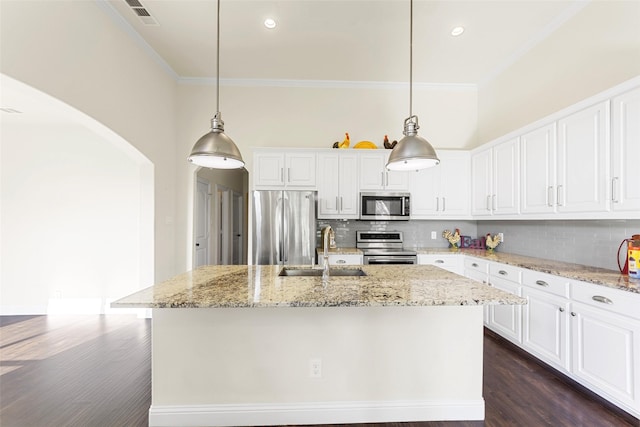 3014 Preston Club Dr, Sherman, TX 75092 - kitchen with stainless steel appliances, crown molding, arched walkways, an island with sink, and decorative backsplash