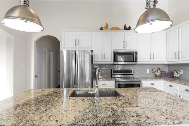 3014 Preston Club Dr, Sherman, TX 75092 - kitchen with stainless steel appliances, tasteful backsplash, white cabinets, and arched walkways