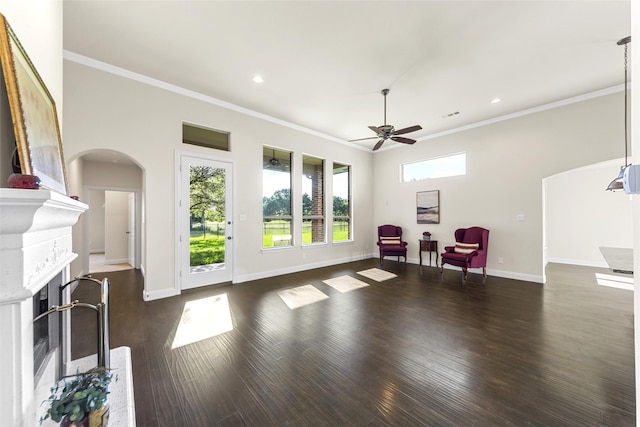 3014 Preston Club Dr, Sherman, TX 75092 - living room featuring ceiling fan, crown molding, a fireplace, arched walkways, and dark wood-style floors