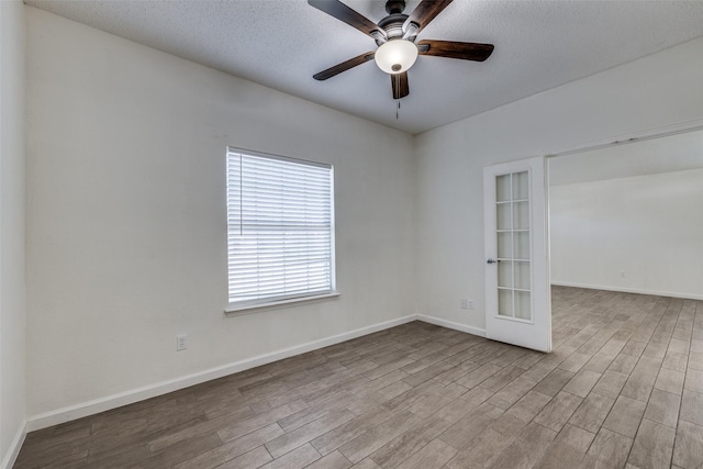 6414 Seaford Rd, Arlington, TX 76001 - empty room with a ceiling fan, wood finished floors, a textured ceiling, and french doors