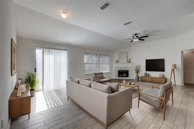 6414 Seaford Rd, Arlington, TX 76001 - living room with healthy amount of natural light, ceiling fan, a textured ceiling, wood finish floors, and a fireplace