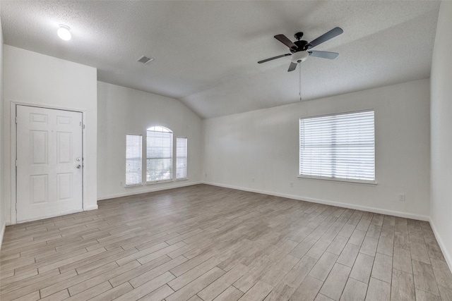 6414 Seaford Rd, Arlington, TX 76001 - unfurnished room featuring light wood-style floors, ceiling fan, lofted ceiling, and a textured ceiling