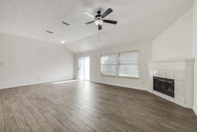 6414 Seaford Rd, Arlington, TX 76001 - unfurnished living room with a textured ceiling, vaulted ceiling, ceiling fan, a fireplace, and dark wood-style flooring