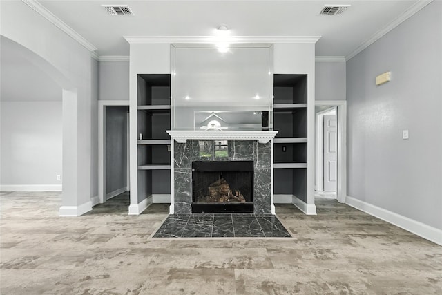 8301 Concord Dr, Rowlett, TX 75089 - unfurnished living room featuring ornamental molding, built in shelves, arched walkways, and a premium fireplace