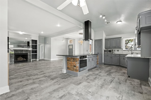 8301 Concord Dr, Rowlett, TX 75089 - kitchen featuring stainless steel appliances, gray cabinets, ventilation hood, a ceiling fan, and open floor plan