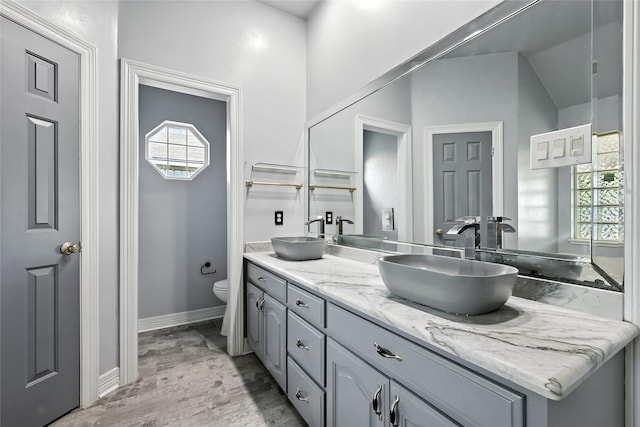8301 Concord Dr, Rowlett, TX 75089 - bathroom featuring double vanity, healthy amount of natural light, and wood finished floors