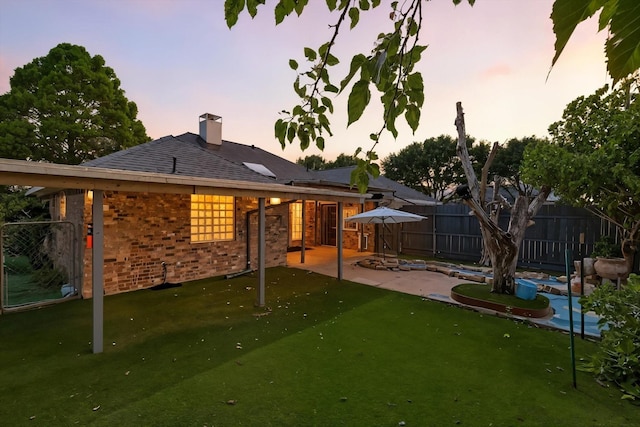 8301 Concord Dr, Rowlett, TX 75089 - back of house at dusk with brick siding, a patio, a chimney, and a swimming pool