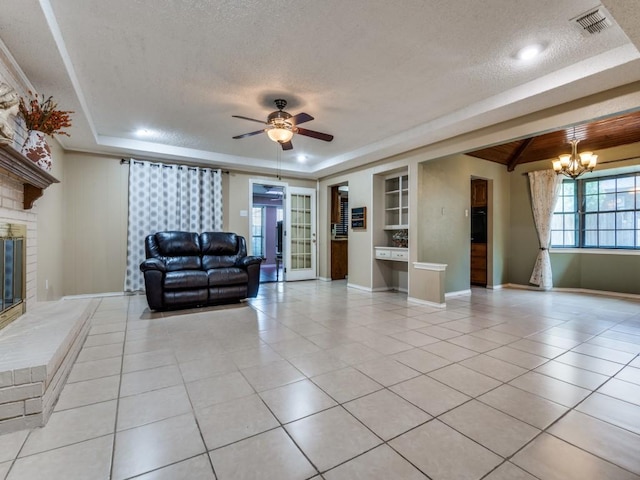 713 Bordner Dr, Lancaster, TX 75146 - living area featuring a textured ceiling, a chandelier, built in shelves, light tile patterned floors, and a ceiling fan