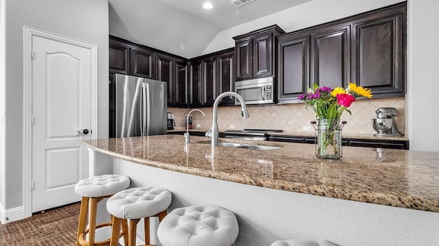 3513 Holly Rd, Melissa, TX 75454 - kitchen with stainless steel appliances, a kitchen bar, light stone countertops, decorative backsplash, and lofted ceiling