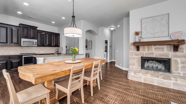 3513 Holly Rd, Melissa, TX 75454 - dining space with arched walkways, recessed lighting, and a stone fireplace