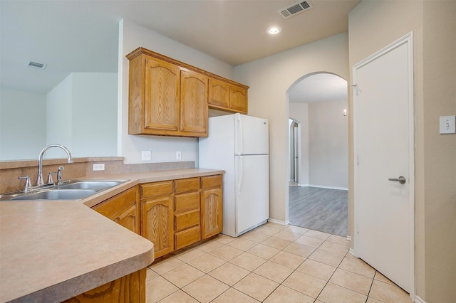 5831 Melanie Ct, Fort Worth, TX 76131 - kitchen with arched walkways, freestanding refrigerator, light countertops, light tile patterned flooring, and recessed lighting
