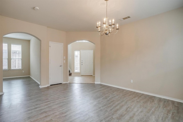 5831 Melanie Ct, Fort Worth, TX 76131 - unfurnished room featuring arched walkways, wood finished floors, a chandelier, a smoke detector, and stairs
