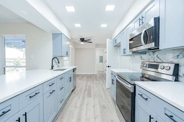 3733 Magnolia Dr, Grand Prairie, TX 75052 - kitchen with appliances with stainless steel finishes, backsplash, light countertops, light wood finished floors, and a ceiling fan