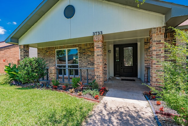 3733 Magnolia Dr, Grand Prairie, TX 75052 - entrance to property featuring a porch, brick siding, and a lawn
