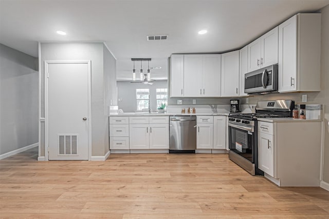 5307 Kelly Elliott, Arlington, TX 76017 - kitchen with appliances with stainless steel finishes, light countertops, light wood-style flooring, white cabinetry, and recessed lighting