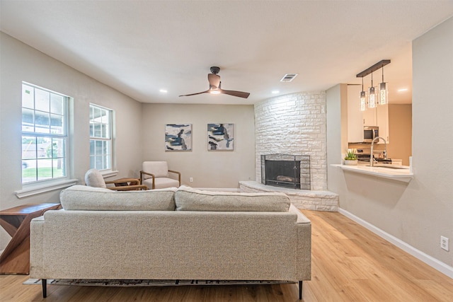 5307 Kelly Elliott, Arlington, TX 76017 - living room with a stone fireplace, light wood-style flooring, ceiling fan, and recessed lighting