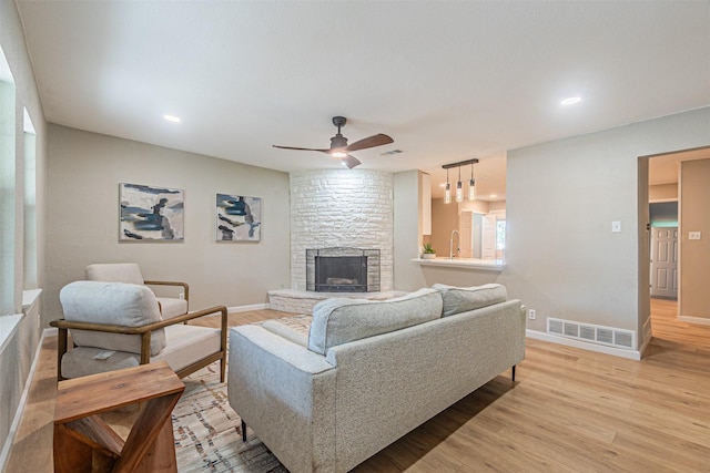 5307 Kelly Elliott, Arlington, TX 76017 - living area with light wood-style flooring, a ceiling fan, a stone fireplace, and recessed lighting
