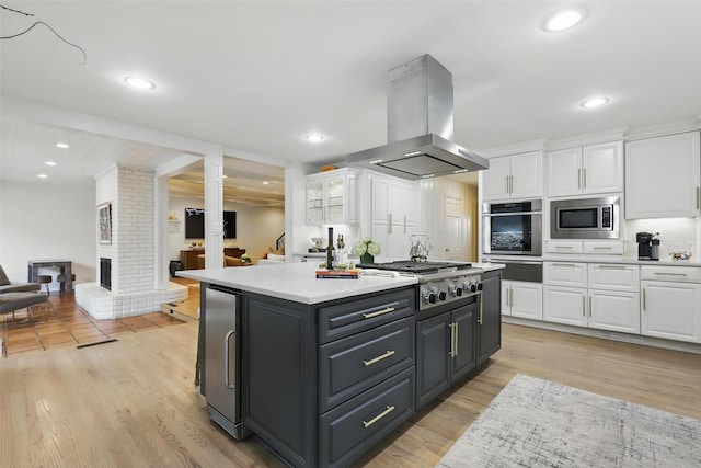 208 Rockwood Park Dr, Fort Worth, TX 76107 - kitchen with island exhaust hood, appliances with stainless steel finishes, white cabinets, a warming drawer, and recessed lighting