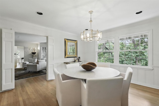 208 Rockwood Park Dr, Fort Worth, TX 76107 - dining room featuring a chandelier, light wood-style flooring, ornamental molding, healthy amount of natural light, and a decorative wall