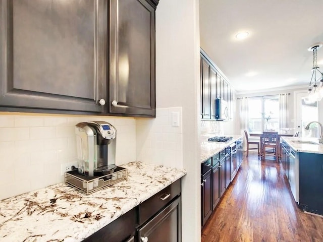301 Komron Ct, Prosper, TX 75078 - kitchen featuring dark wood-type flooring, tasteful backsplash, light stone counters, and white microwave