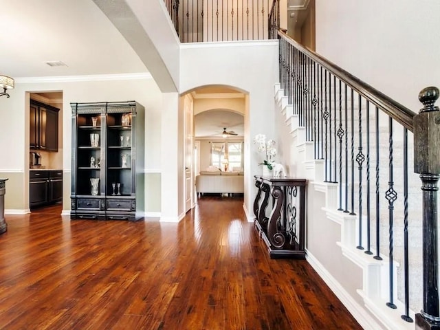 301 Komron Ct, Prosper, TX 75078 - entrance foyer featuring wood finished floors, stairs, arched walkways, ornamental molding, and a ceiling fan