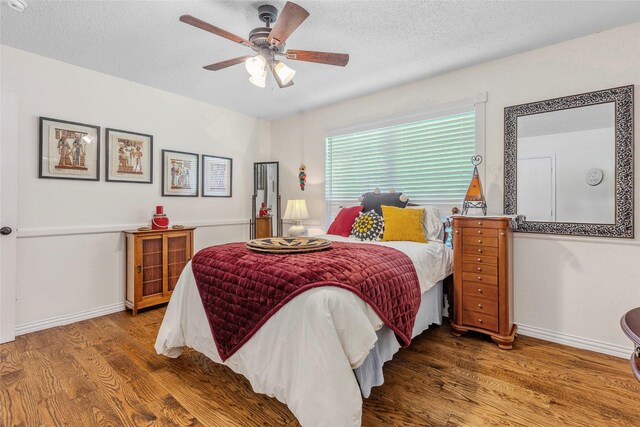 7210 Mercurys Rd, Rowlett, TX 75089 - bedroom with wood finished floors, a textured ceiling, and ceiling fan