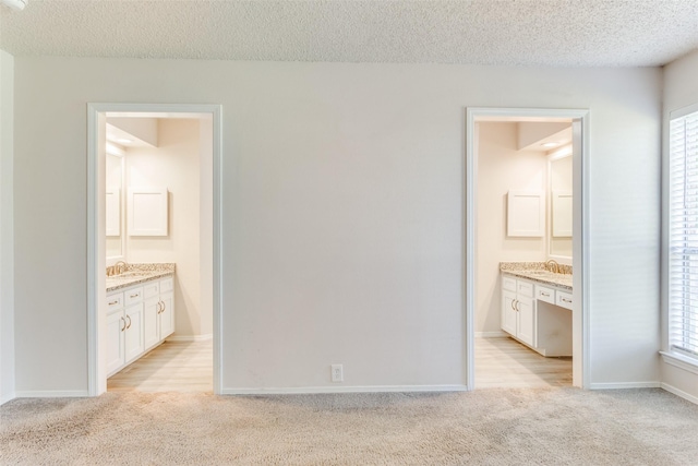 1704 Edge Hill Rd, Benbrook, TX 76126 - unfurnished bedroom featuring light carpet, a textured ceiling, and ensuite bathroom