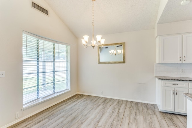 1704 Edge Hill Rd, Benbrook, TX 76126 - unfurnished dining area with a chandelier, light wood-style floors, lofted ceiling, and a textured ceiling