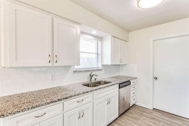 1704 Edge Hill Rd, Benbrook, TX 76126 - kitchen with stainless steel dishwasher, light wood-style floors, decorative backsplash, white cabinets, and light stone countertops