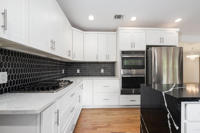 5710 Forest Ln, Dallas, TX 75230 - kitchen featuring appliances with stainless steel finishes, backsplash, recessed lighting, white cabinetry, and light wood-type flooring
