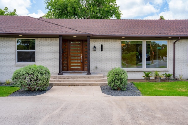 5710 Forest Ln, Dallas, TX 75230 - property entrance featuring a shingled roof and brick siding