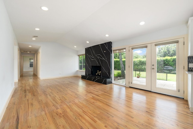 5710 Forest Ln, Dallas, TX 75230 - unfurnished living room with light wood finished floors, plenty of natural light, lofted ceiling, recessed lighting, and french doors