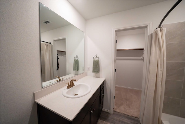 3117 Harper St, Little Elm, TX 75068 - bathroom with wood finished floors, vanity, a spacious closet, and shower / bath combo with shower curtain