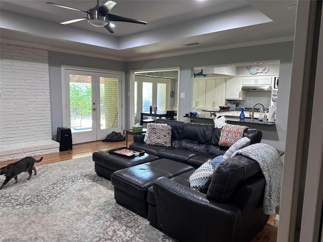 5620 Ridgetown Cir, Dallas, TX 75230 - living room featuring a tray ceiling, a ceiling fan, wood finished floors, french doors, and crown molding