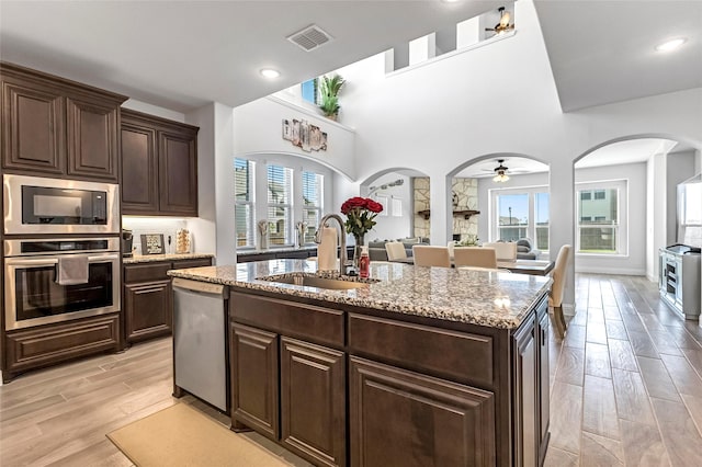 303 Hidden Cove Dr, Ponder, TX 76259 - kitchen featuring stainless steel appliances, light wood-style flooring, light stone counters, dark brown cabinets, and recessed lighting