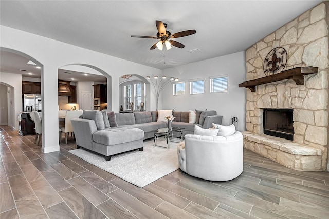 303 Hidden Cove Dr, Ponder, TX 76259 - living area featuring ceiling fan, arched walkways, a fireplace, and wood finish floors