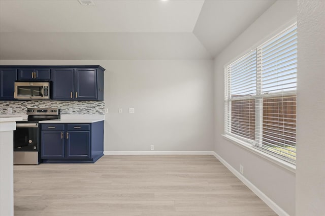 1909 Morning Dove, Aubrey, TX 76227 - kitchen featuring appliances with stainless steel finishes, vaulted ceiling, light wood finished floors, light countertops, and backsplash