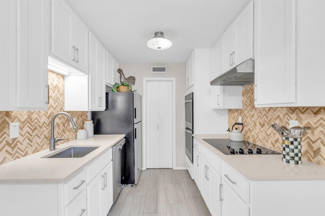 10763 Villager Unit A, Dallas, TX 75230 - kitchen with under cabinet range hood, appliances with stainless steel finishes, backsplash, white cabinets, and light countertops