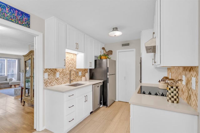 10763 Villager Unit A, Dallas, TX 75230 - kitchen with stainless steel appliances, tasteful backsplash, range hood, white cabinets, and light countertops
