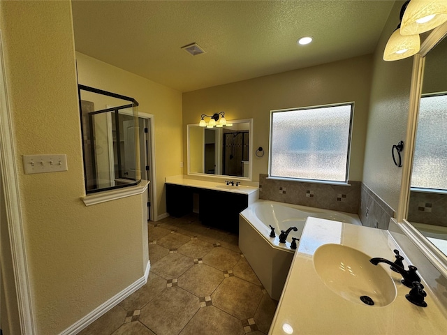 205 Boardwalk Ave, Waxahachie, TX 75165 - bathroom featuring a garden tub, a shower stall, vanity, tile patterned floors, and a textured ceiling