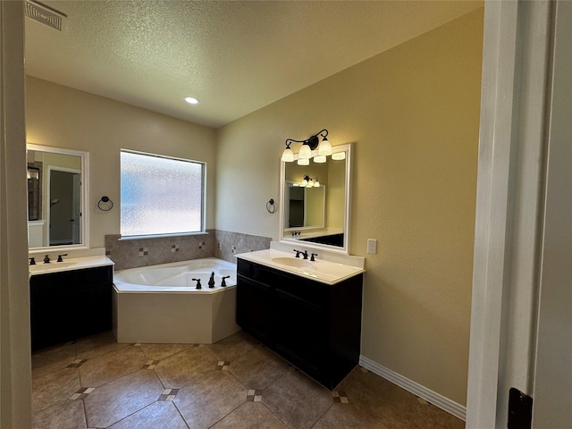205 Boardwalk Ave, Waxahachie, TX 75165 - bathroom featuring a bath, two vanities, tile patterned floors, and a textured ceiling