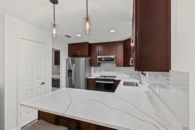 9013 Topperwind Ct, Fort Worth, TX 76134 - kitchen with appliances with stainless steel finishes, a peninsula, light stone counters, decorative light fixtures, and decorative backsplash