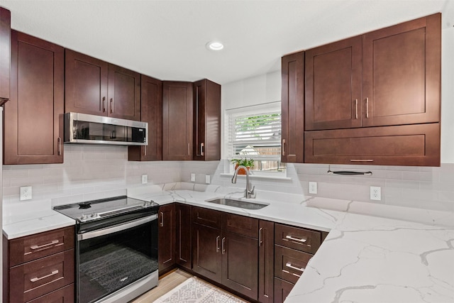 9013 Topperwind Ct, Fort Worth, TX 76134 - kitchen featuring appliances with stainless steel finishes, decorative backsplash, light stone counters, dark brown cabinetry, and recessed lighting