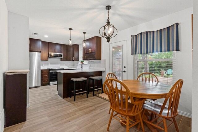 9013 Topperwind Ct, Fort Worth, TX 76134 - dining space with light wood-type flooring and a chandelier