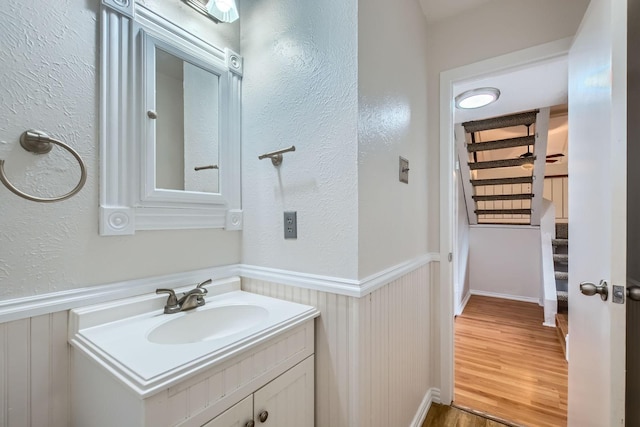 902 Via Valencia, Mesquite, TX 75150 - bathroom featuring wainscoting, vanity, wood finished floors, and a textured wall
